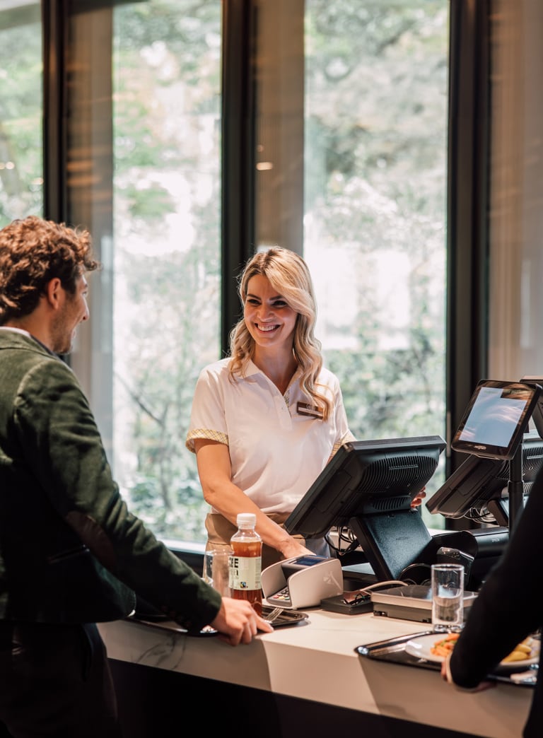 Kunde und Mitarbeiterin an der Rezeption eines modernen Büros.