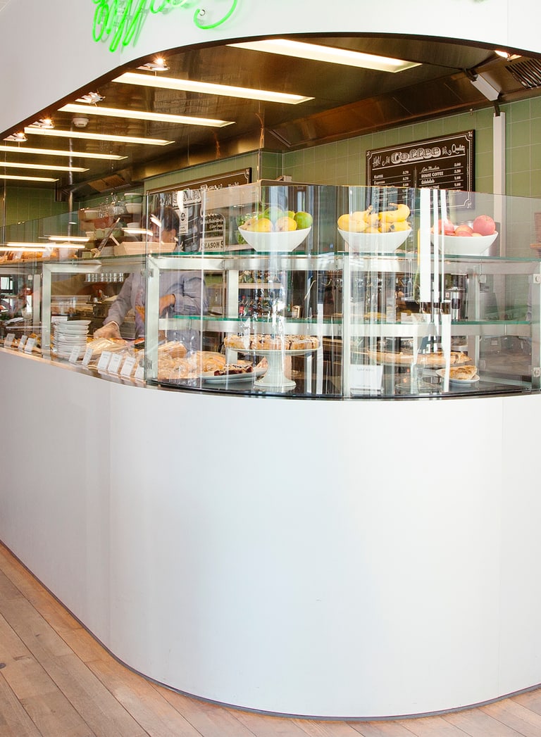 Cafeteria mit Theke und zwei Personen in Gesprächen.