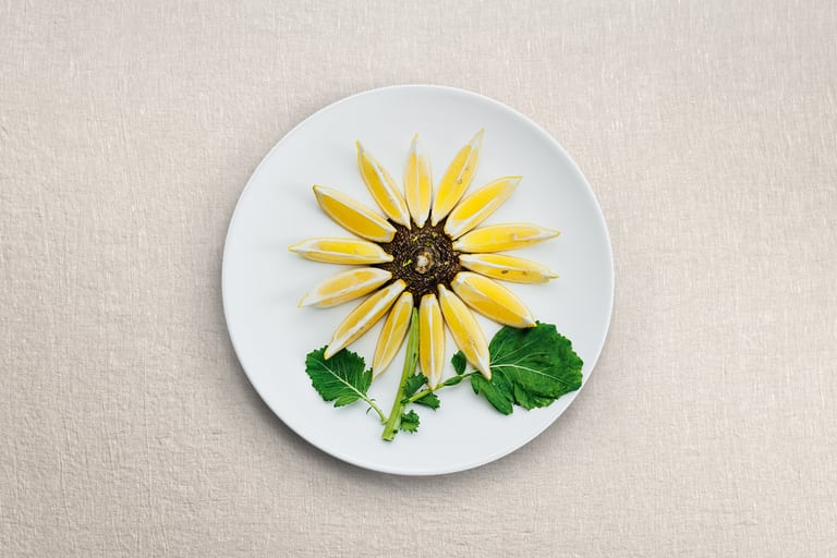 Sonnenblumenanordnung auf einem weissen Teller.