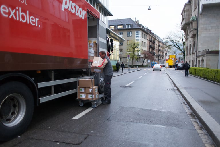 Lieferwagen mit Person beim Beladen an einer städtischen Strasse.