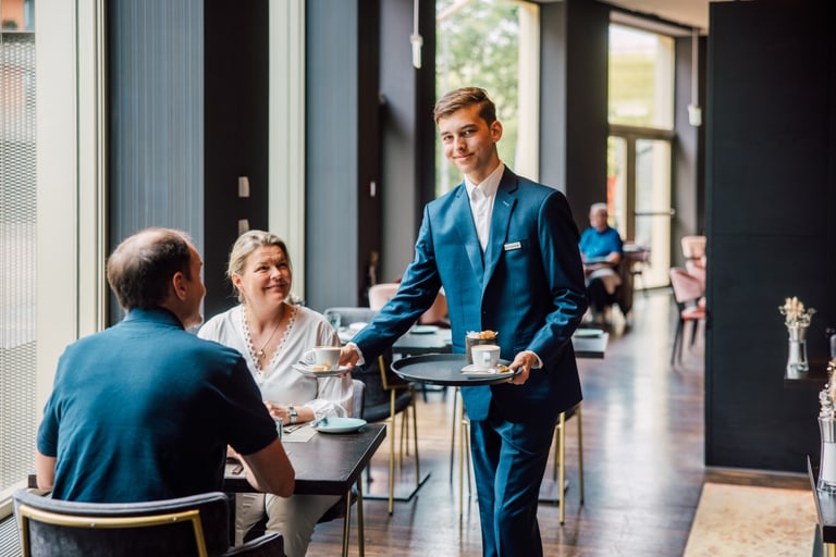 Kellner serviert Kaffee für Paar im Restaurant.