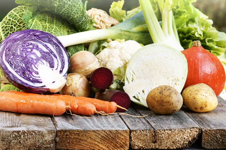 Saisonal, frische Gemüse wie Kohl, Karotten und Kartoffeln auf Holzuntergrund.