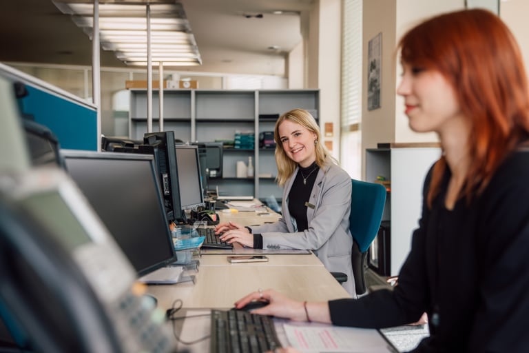 Zwei Frauen arbeiten an Computern in einem Büro.