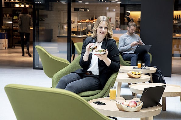 Frau sitzt in einem gemütlichen Cafe und geniesst ihr Mittagessen.