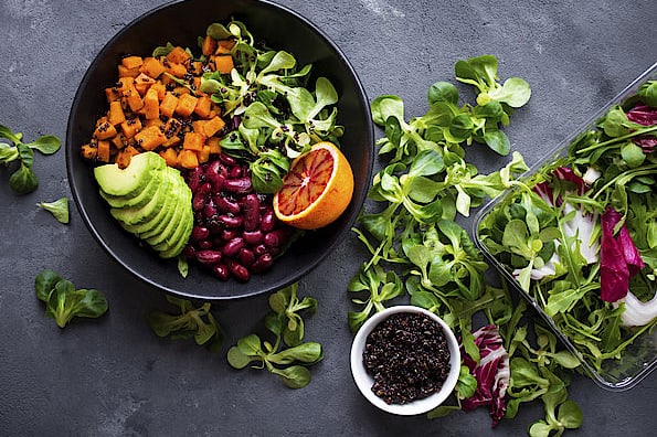 Eine ausgewogene und vielfältige Salatschüssel mit Avocado, Nüsslisalat, Quinoa und roten Bohnen.