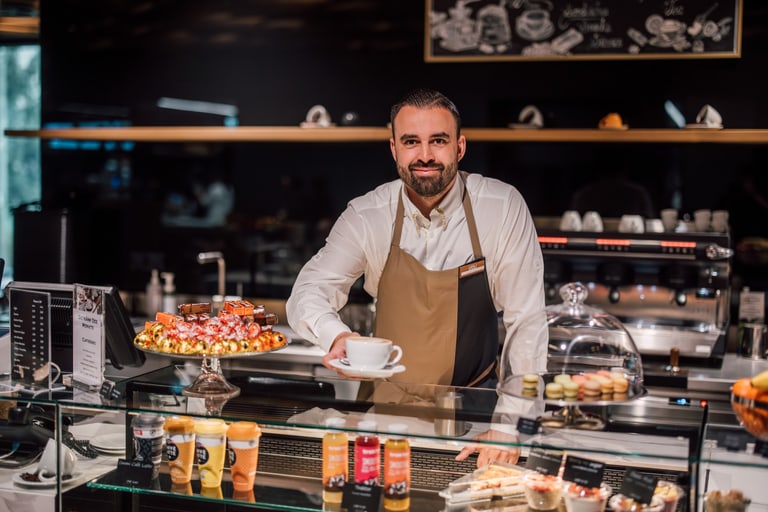 Barista bietet Kaffee an der Theke eines Cafés an.