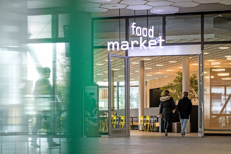 Eingang zum Food Market mit Menschen, die hineingehen.
