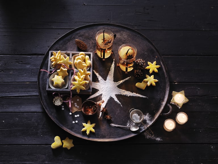 Plätzchen und Getränke auf einem Tablett mit Sternendekoration.