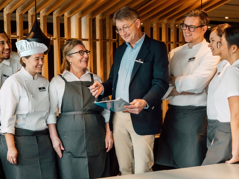 RM mit Küchenpersonal in Uniform im Gespräch.