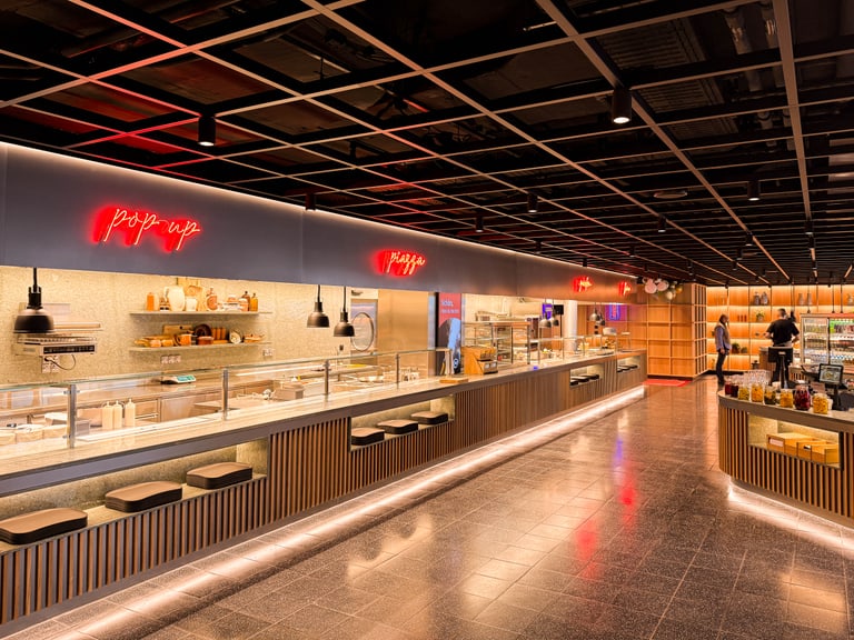 Moderne Kantine mit Buffet und Neonlichtern.