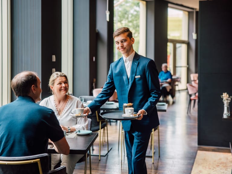 Kellner serviert Kaffee für Paar im Restaurant.