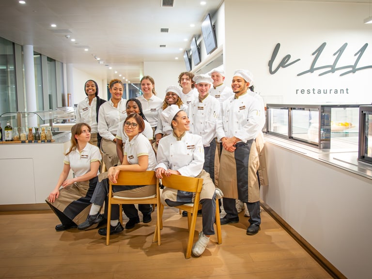 Restaurantteam von Le 111 posiert in Uniformen.