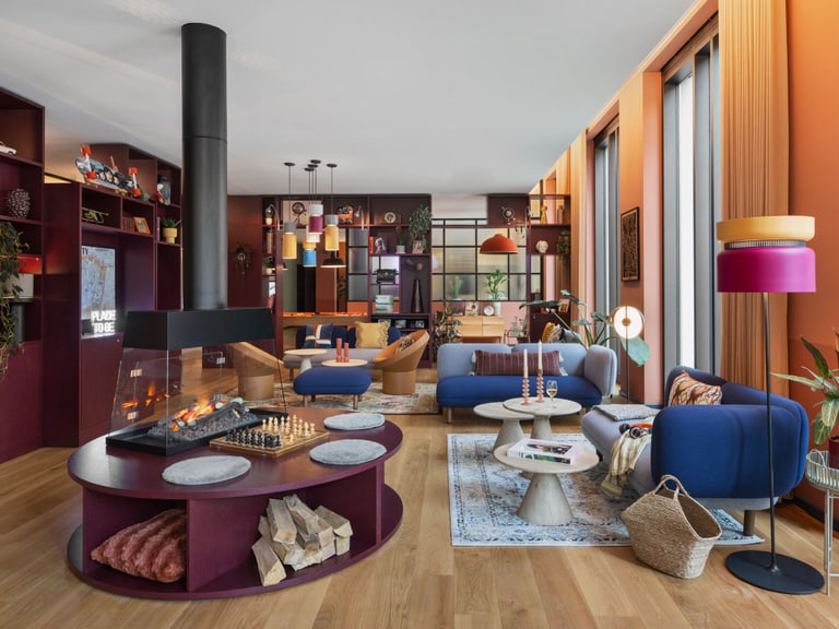 Moderne, helle Wohnzimmer mit Kamin, blauen Sofas und Holzboden.