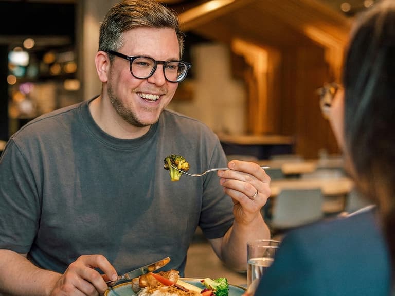 Mann lächelt beim Essen in einem Restaurant.