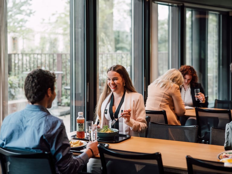 Mann und Frau essen und unterhalten sich in einem Cafeteria-Restaurant.