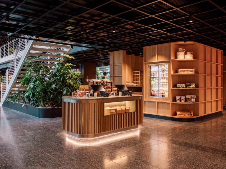 Moderne Café-Lounge mit Holztheke und Pflanzen.