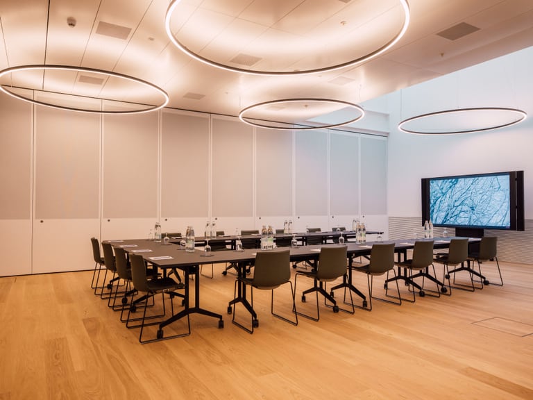 Moderne Café-Lounge mit Holztheke und Pflanzen.