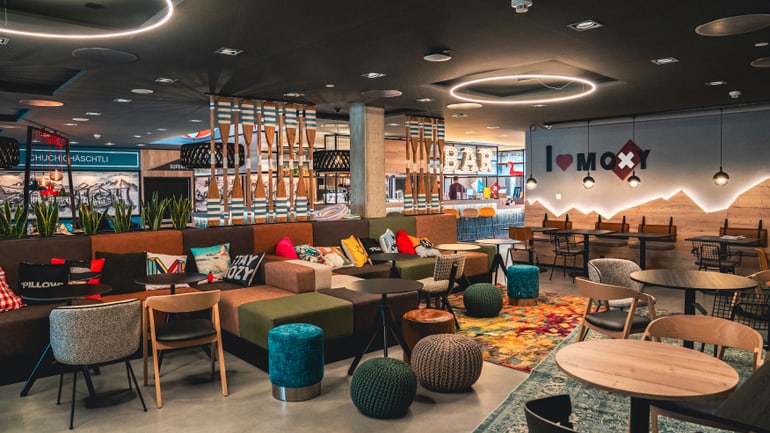 Moderne Bar mit bunten Möbeln und Beleuchtung.