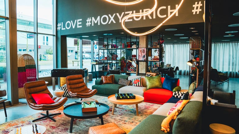 Moderne Hotellobby mit bunten Möbeln und Hashtags an der Wand.