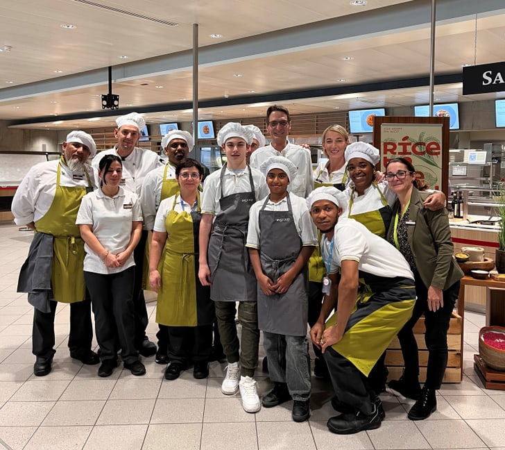 Gruppe von Köchen in einer Kantine posierend für ein Foto.