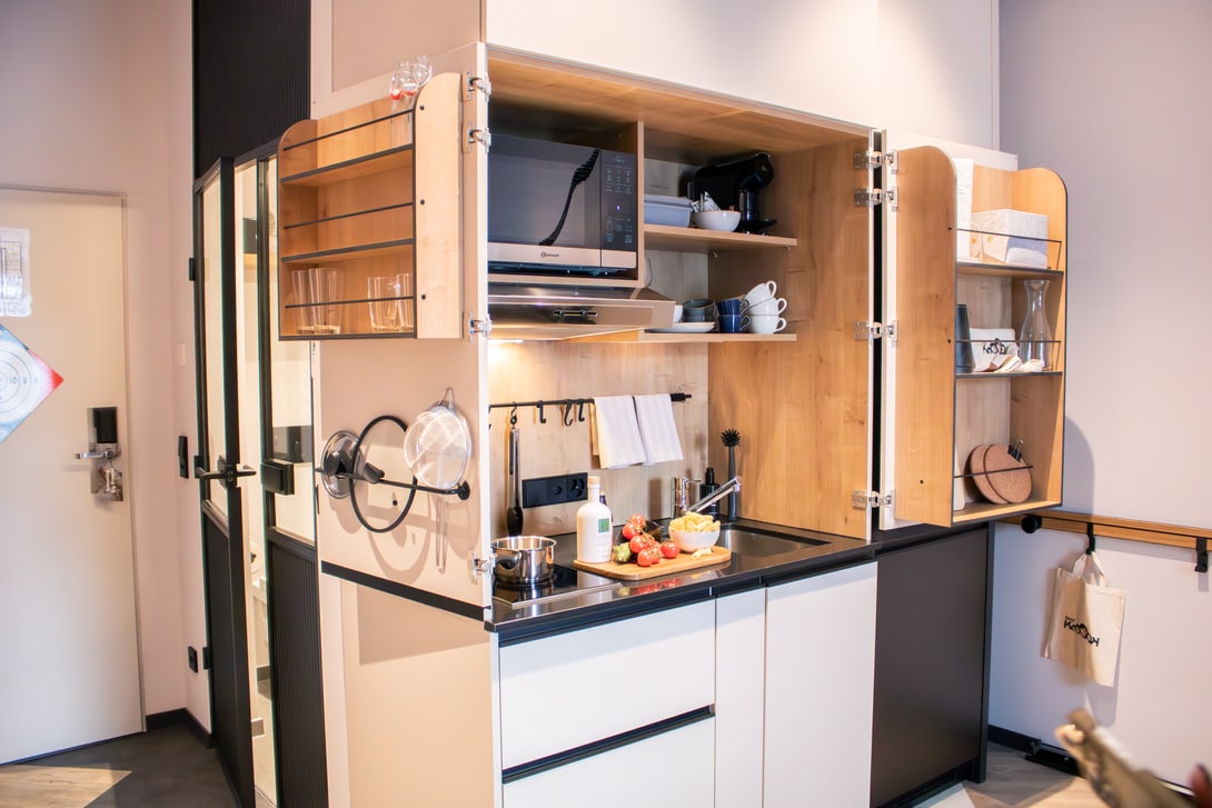 Kitchenette : évier, micro-ondes, lave-vaisselle, plaques de cuisson, plan de travail, réfrigérateur et congélateur - tout le nécessaire dans un minimum d'espace.